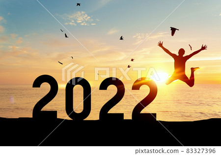 Silhouette man jumping and birds flying with number like 2022 at tropical beach on sunset sky abstract background. Silhouette man jumping and birds flying with number like 2022 at tropical beach on sunset sky abstract background. 83327396