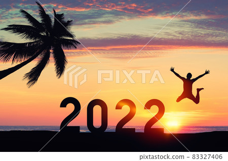 Silhouette man jumping with number like 2022 and palm tree at tropical beach on sunset sky abstract background. Happy new year and holiday celebration concept. 83327406