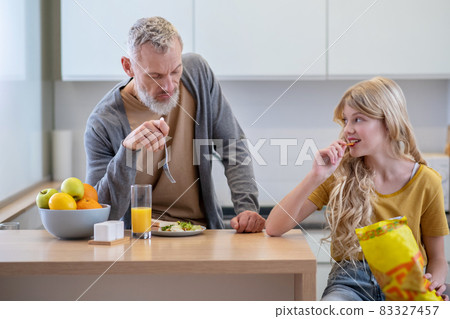 Dad trying to make his daughter eat breakfast Dad trying to make his daughter eat breakfast 83327457