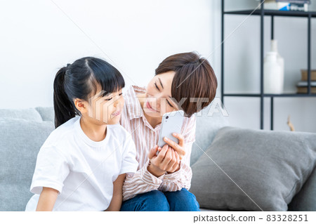 父母和孩子(母子)在客廳裡看著智能手機時放鬆 父母和孩子(母子)在客廳裡看著智能手機時放鬆 83328251