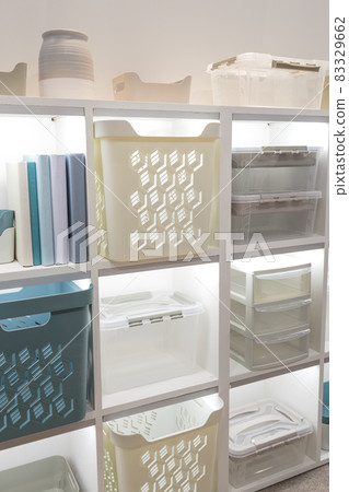 Plastic container boxes on a shelf on a rack for organizing home space and storing things, order and interior, selling household goods. Industrial background Plastic container boxes on a shelf on a rack for organizing home space and storing things, order and interior, selling household goods. Industrial background 83329662