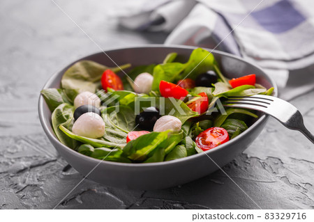 Fresh salad with mozzarella cheese, tomato, spinach close-up. Healthy food. Fresh salad with mozzarella cheese, tomato, spinach close-up. Healthy food. 83329716