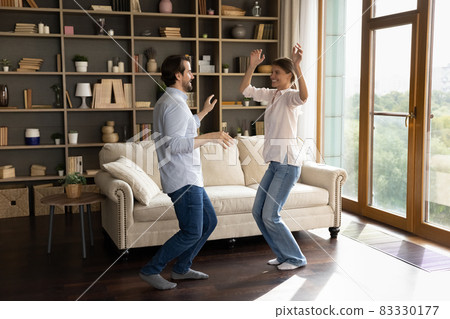 Happy young family couple dancing in living room. Happy young family couple dancing in living room. 83330177