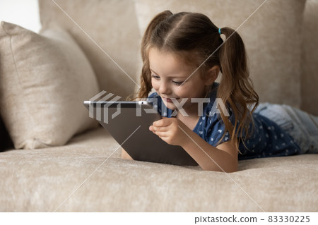 Happy adorable little 6s kid using tablet. 83330225
