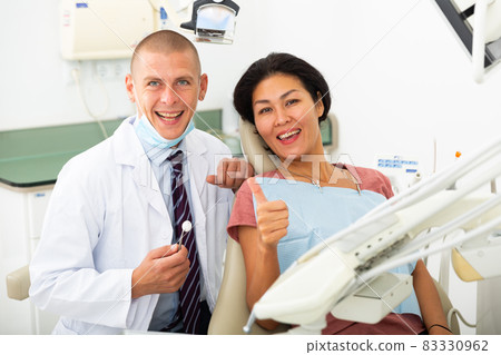 Satisfied patient visiting dentist giving thumbs up 83330962