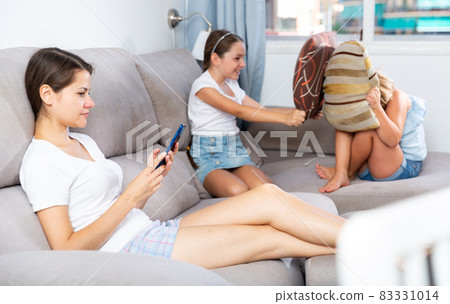 Little girlfriends play pillows on the couch 83331014