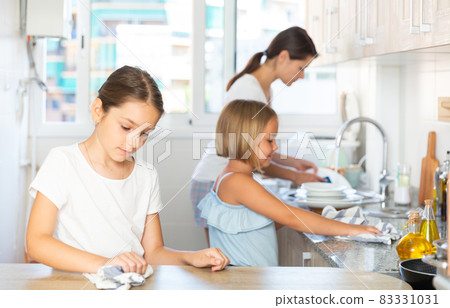 Family working at kitchen, girl cleaning table Family working at kitchen, girl cleaning table 83331031