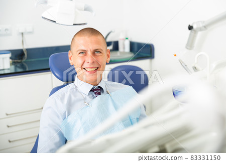 Portrait of a positive man patient sitting in a dental chair Portrait of a positive man patient sitting in a dental chair 83331150