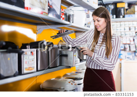Woman choosing deep fryer Woman choosing deep fryer 83331153
