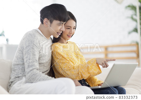 Young couple using laptop watching video together Young couple using laptop watching video together 83332373