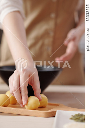 Woman Putting Dough Balls on Board 83332815