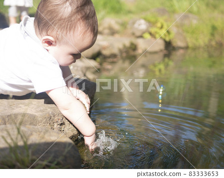 Half baby playing in the water of the pond 83333653