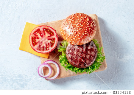 Burger ingredients, shot from above on a wooden board. Hamburger beef patty Burger ingredients, shot from above on a wooden board. Hamburger beef patty 83334158