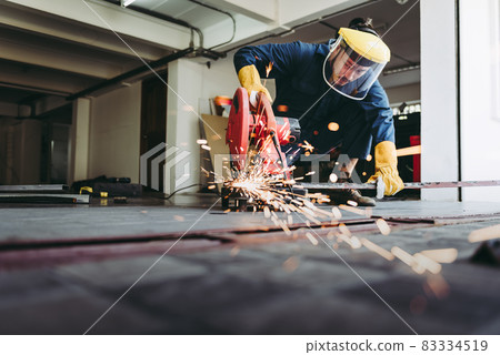 Craftsman Welding is Cutting Steel Work in Fabrication Workshop, Welder Man in Safety Protective Equipments Doing Metalwork in Construction Site. Steel Labor Skill and Workshops Production Concept 83334519