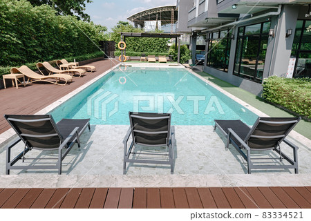 Swimming Pool Ladder and Sun Lounger in Poolside, Luxury Outdoor Swim Pool and Modern Decoration of Resort Hotel. Relaxation Swimming Pool in Summer Holiday and Leisure Vacation Lifestyles. 83334521