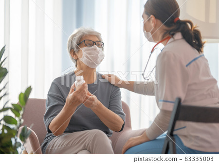 Doctor and senior woman wearing facemasks Doctor and senior woman wearing facemasks 83335003