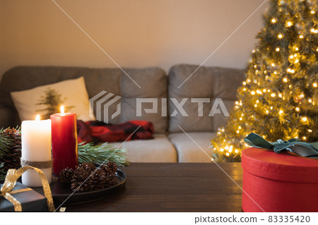 Blurred home interior in living room with Christmas tree, wooden tabletop and candles. Xmas. Blurred home interior in living room with Christmas tree, wooden tabletop and candles. Xmas. 83335420