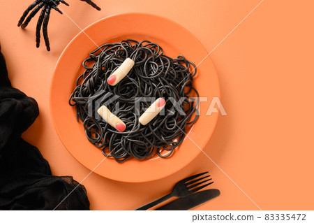 Halloween Italian black pasta decorated funny spiders in orange plate on orange . 83335472
