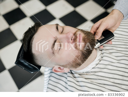 Man's hands watchmaking a beard 83336902
