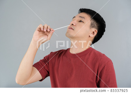man using coronavirus(covid-19) rapid antigen self test kit (atk) at home with cotton nasal swab 83337925