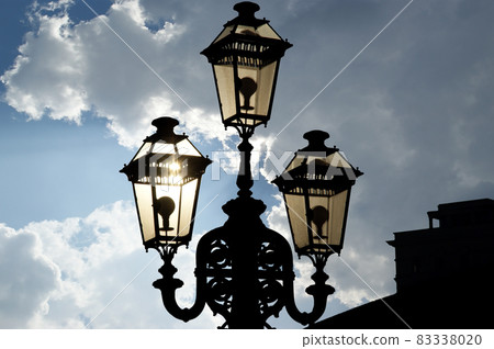Vintage decorative street lamp in the backlight setting sun Vintage decorative street lamp in the backlight setting sun 83338020