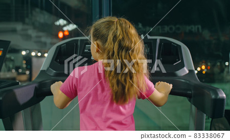 Fit Athletic Baby Girl Running on the Treadmill, Doing Her Fitness Exercise. Cute Children Actively Training in Modern Gym. Sports Child Workout 83338067