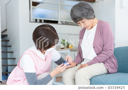 Visiting medical care: An elderly woman who has a nurse measure oxygen saturation with a pulse oximeter 83339425