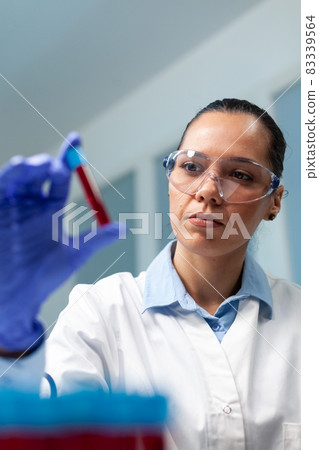 Scientist doctor holding blood vacutainer analyzing during biochemistry experiment 83339564