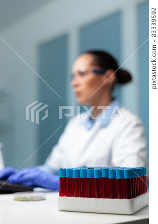 Selective focus on transparent vacutainer with blood standing on table Selective focus on transparent vacutainer with blood standing on table 83339592