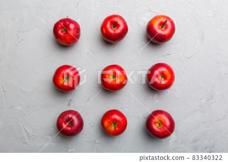 Many red apples on colored background, top view. Autumn pattern with fresh apple above view Many red apples on colored background, top view. Autumn pattern with fresh apple above view 83340322