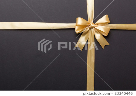 Top view of gold ribbon rolled and yellowbow isolated on colored background. Flat lay with copy space Top view of gold ribbon rolled and yellowbow isolated on colored background. Flat lay with copy space 83340446