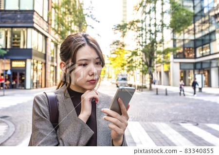 在東京丸之內操作智能手機的年輕女性 在東京丸之內操作智能手機的年輕女性 83340855