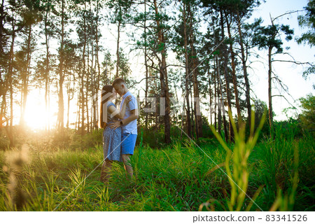 Happy couple in love in springtime at sunset. Woman and man holding hands and hugging. 83341526