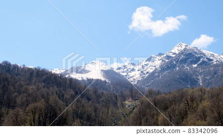 beautiful landscape of snow-capped mountains with white clouds on blue sky on a sunny day at 83342096