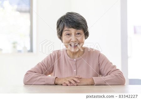 Portrait of an elderly woman smiling looking at the camera 83342227