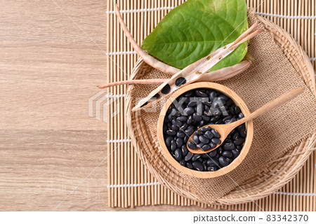 Black kidney beans in a bowl with spoon on wooden background, Table top view 83342370