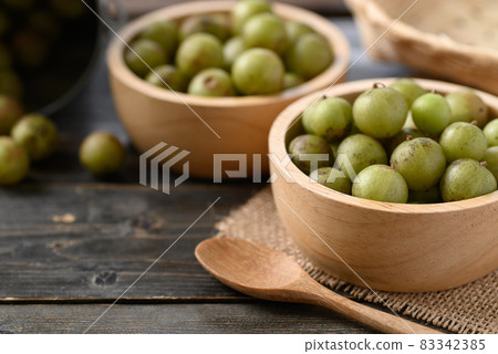 Wild Indian gooseberry or amla in a bowl on wooden background Wild Indian gooseberry or amla in a bowl on wooden background 83342385