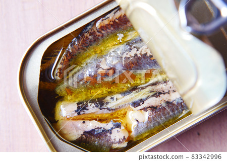 open tin of sardines on white tiles background. 83342996