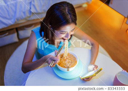 woman eating instant noodles 83343333