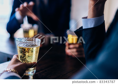 Male and female office workers drinking alcohol at the bar Male and female office workers drinking alcohol at the bar 83343787