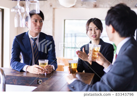 Male and female office workers drinking alcohol at the bar Male and female office workers drinking alcohol at the bar 83343796
