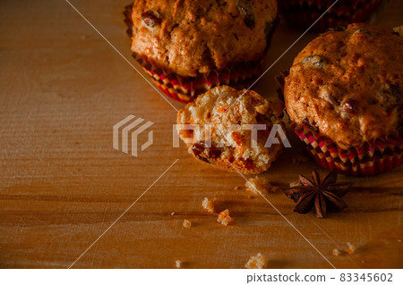 Freshly baked homemade muffins with raisins and carrots. Vegetarian pastries on a wooden background. Place for text. Freshly baked homemade muffins with raisins and carrots. Vegetarian pastries on a wooden background. Place for text. 83345602