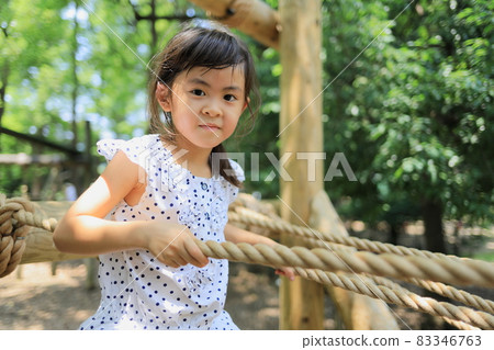 Elementary school girl playing on a tightrope (6 years old) 83346763