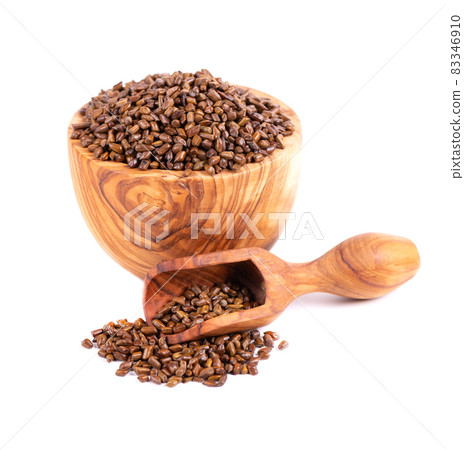 Cassia tora beans in olive bowl and scoop, isolated on white background. Sicklepod or Senna obtusifolia. Clipping path. 83346910