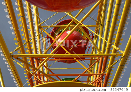 Attraction (Carousel) Ferris wheel on the background of the cloudy sky 83347649