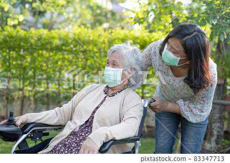 Help Asian senior or elderly old lady woman on electric wheelchair and wearing a face mask for protect safety infection Covid-19 Coronavirus in park. Help Asian senior or elderly old lady woman on electric wheelchair and wearing a face mask for protect safety infection Covid-19 Coronavirus in park. 83347713