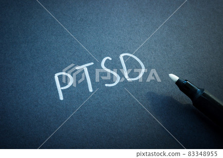 PTSD or Post Traumatic Stress Disorder handwritten on the black sheet of paper. 83348955