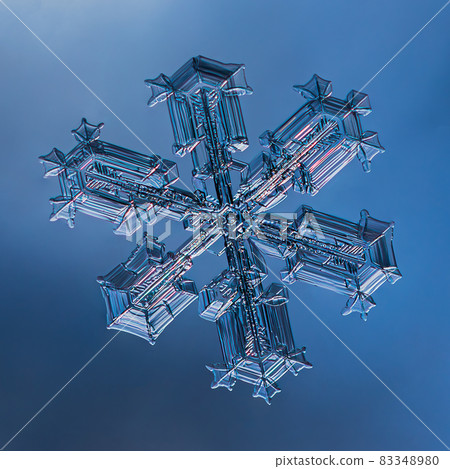 Snowflake on smooth gradient background. Macro photo of real snow crystal on glass surface. This is small snowflake with unusual pattern. Snowflake on smooth gradient background. Macro photo of real snow crystal on glass surface. This is small snowflake with unusual pattern. 83348980