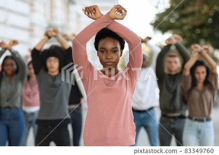 African-american woman guiding multiracial group of activists, crossing fists up 83349760