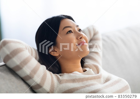 Portrait Of Calm Beautiful Young Asian Female Leaning Back On Comfortable Couch Portrait Of Calm Beautiful Young Asian Female Leaning Back On Comfortable Couch 83350279